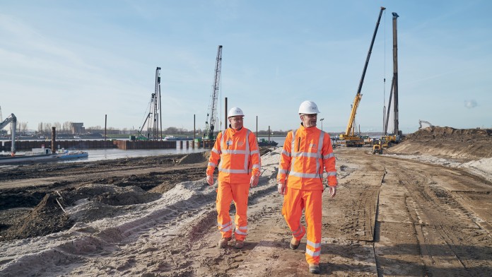 construction workers in orange working clothes at construction site