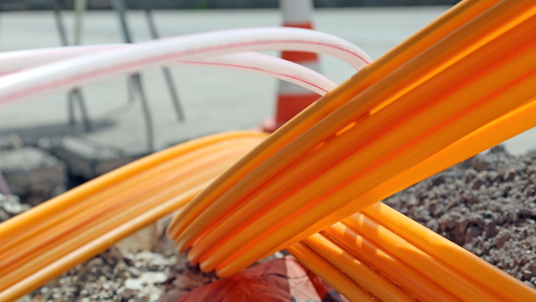 orange und rosafarbene Kabel ragen aus der Erde