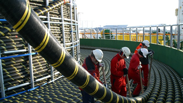 several men unroll huge power cable