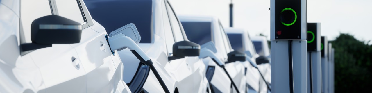 White electric cars at charging stations