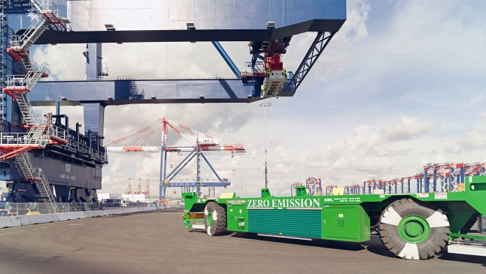 langes grünes Transportfahrzeug in Containerhafen
