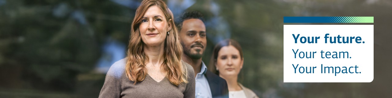 Woman in the foreground and a man and woman in the background looking at the camera