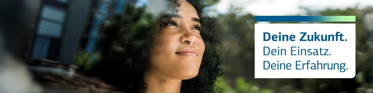 Junge Frau blickt aus dem Fenster in die Ferne
