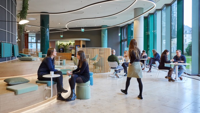 Menschen sitizen in der GreenLounge der KfW IPEX-Bank