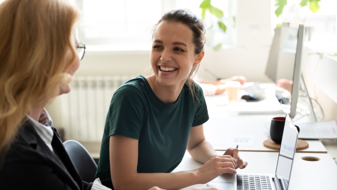 smiling intern talking to an older employee