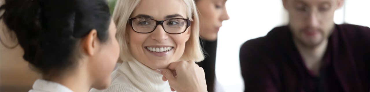 An older and a younger woman in conversation in front of a laptop