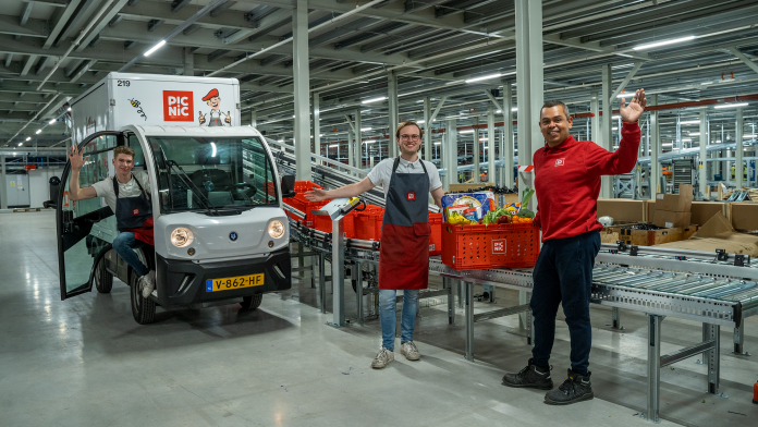 Logistikhalle des Picnic Online Supermarktes mit Fahrzeug und Menschen