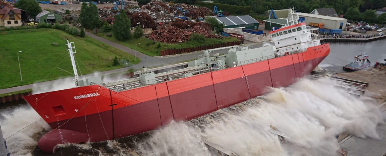 roter Zementfrachter wird zu Wasser gelassen