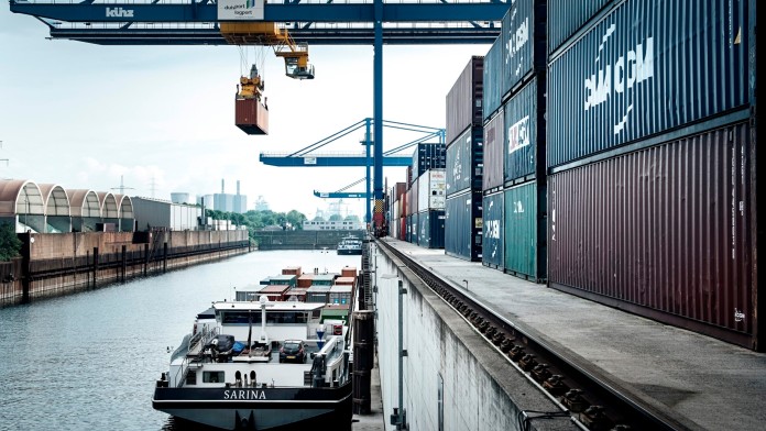 View of an inland port with crane installations, containers, and ships