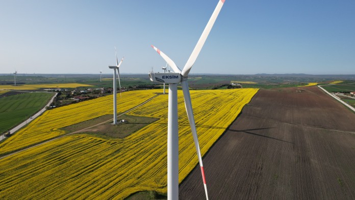 Windräder mit gelbem Feld im Hintergrund