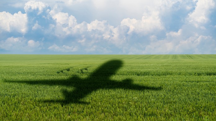 Schatten eines Flugzeugs über einer landwirtschaftlichen Anbaufläche