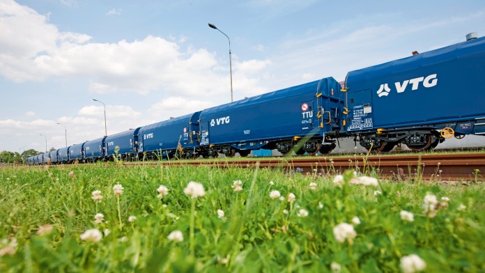 Blauer Zug mit Aufschrift VTG vor Blumenwiese