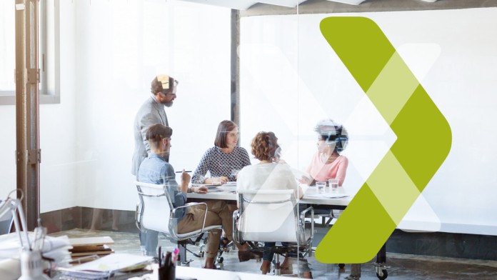 People sitting and standing around a conference table