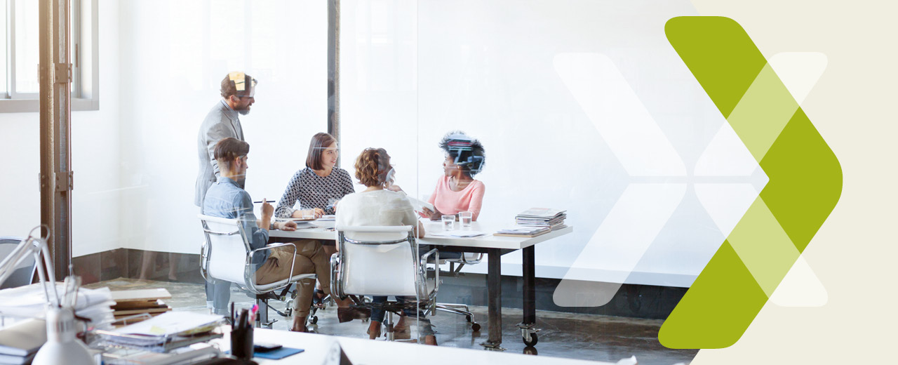 People sitting and standing around a conference table