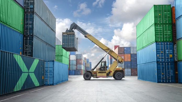 Gezeigt wird ein Containerterminal mit Kran beim Verladen von Franchtcontainern. Die Bildthemen sind Logistik, globaler Handel und Lieferkettenmanagement.