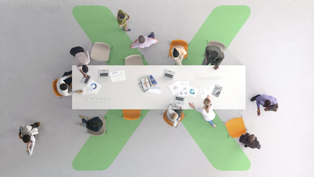 Draufsicht auf eine Gruppe von Menschen, vermutliche Geschftsleute, bei einem Meeting an einem großen Konferenztisch. Auf dem Tisch stehen Laptops und sind Dokumente mit Diagrammen zu sehen. Hier wird Zusammenarbeit in einem modernen Büro gezeigt.