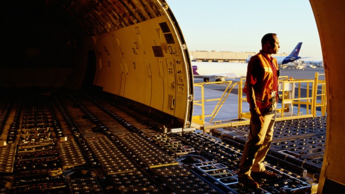 Ein Mann blickt aus einem offenem Cargo Flugzeug, das auf dem Boden steht