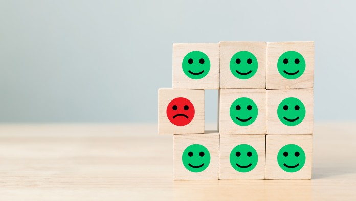 Wooden blocks with icon face emotion happiness in green and sadness in red